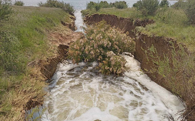 Farmers assessing damage caused to farmland by flooding of mine dam Farmers assessing damage caused to farmland by flooding of mine dam